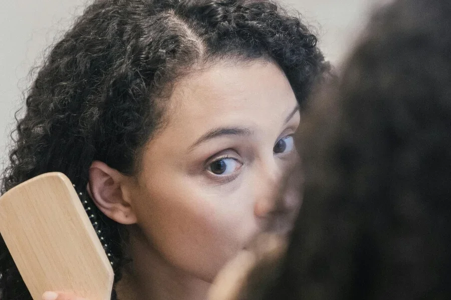 Woman brushing her hair with a detangling brush