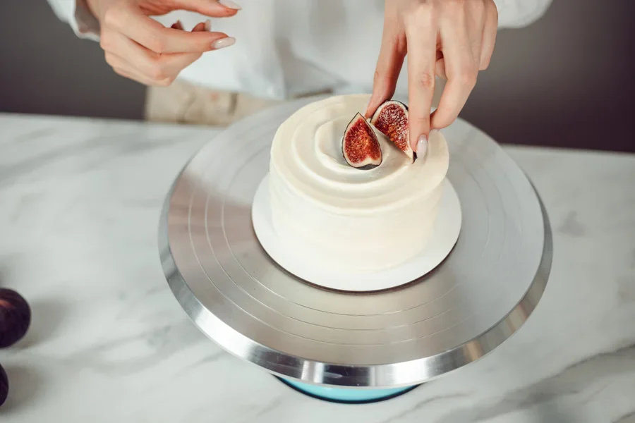 Woman displaying a small cake on a rotating display stand