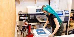 Женщина печатает футболки с фотографиями на заказ