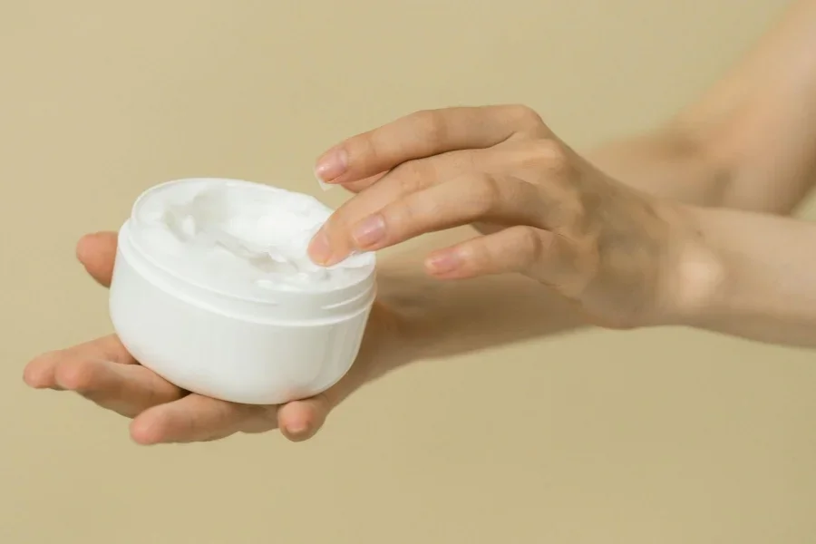 Mujer sacando un producto cosmético de un envase