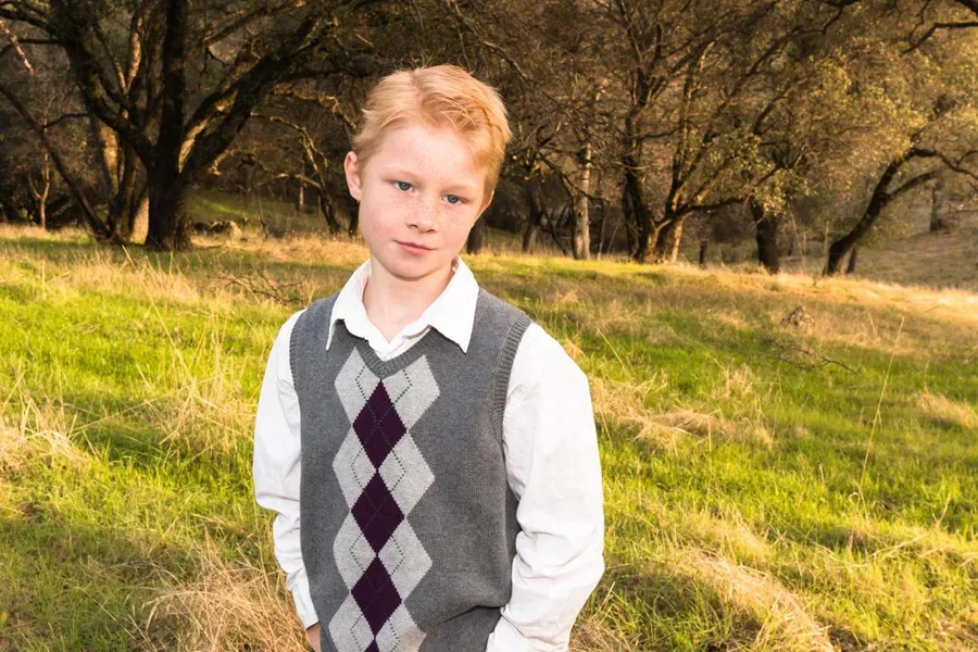 Kleiner Junge steht im grünen Feld