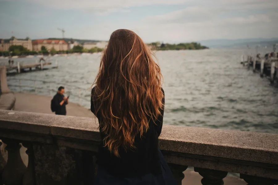 a wavy long hair woman standing on the terrace.