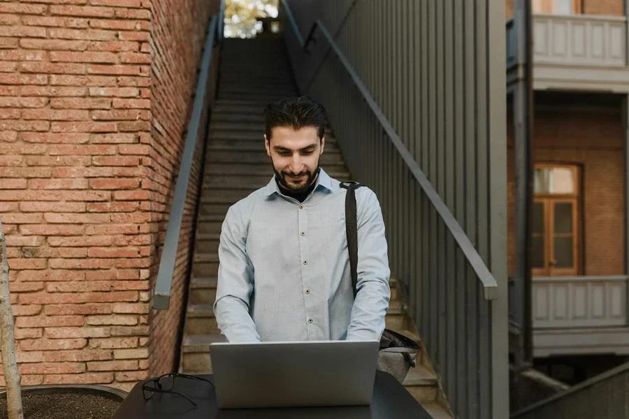 Un homme travaillant sur son ordinateur portable en position debout