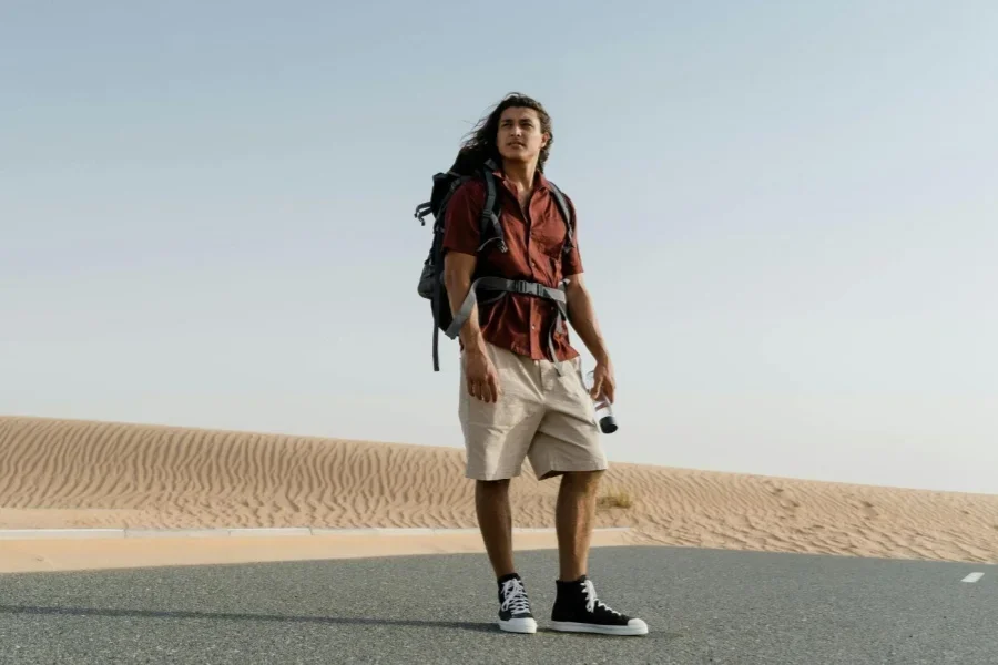 Seorang Pria dengan Ransel Berdiri di Tengah Jalan