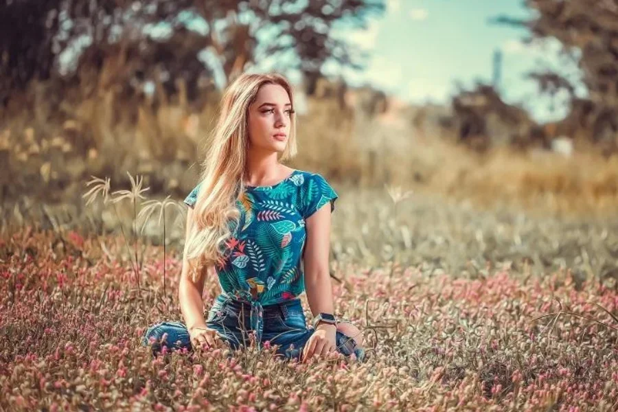 Eine Frau sitzt auf einem Blumenfeld