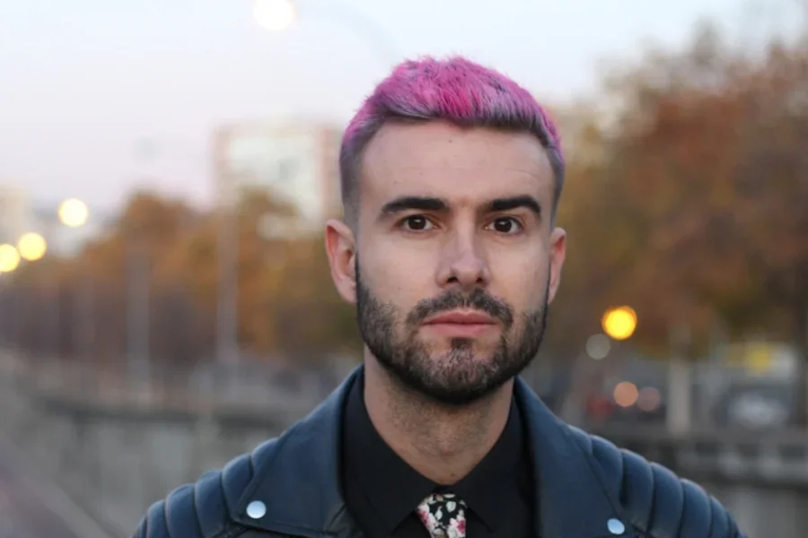 Un hombre guapo con cabello rosa.