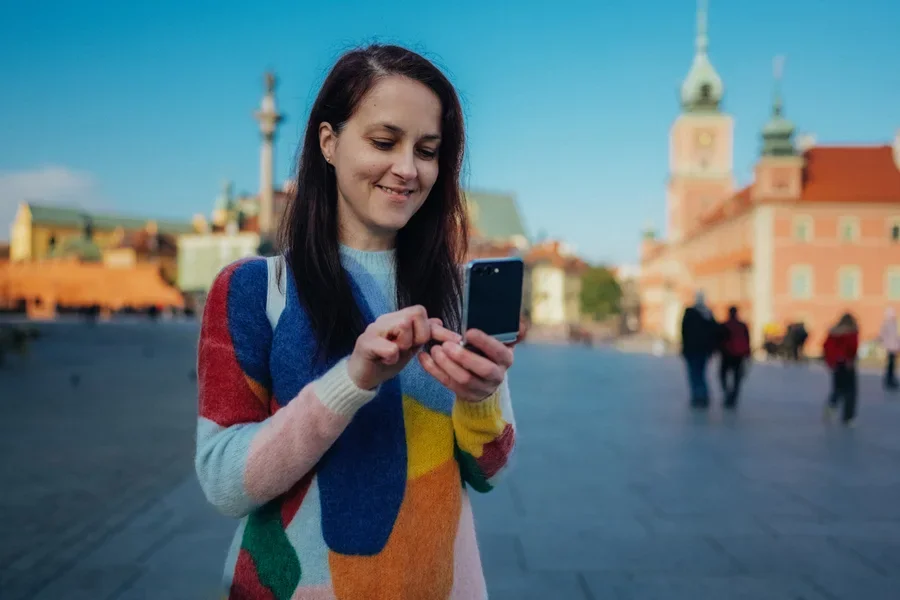 Una dama sonriente con un vestido de suéter colorido.