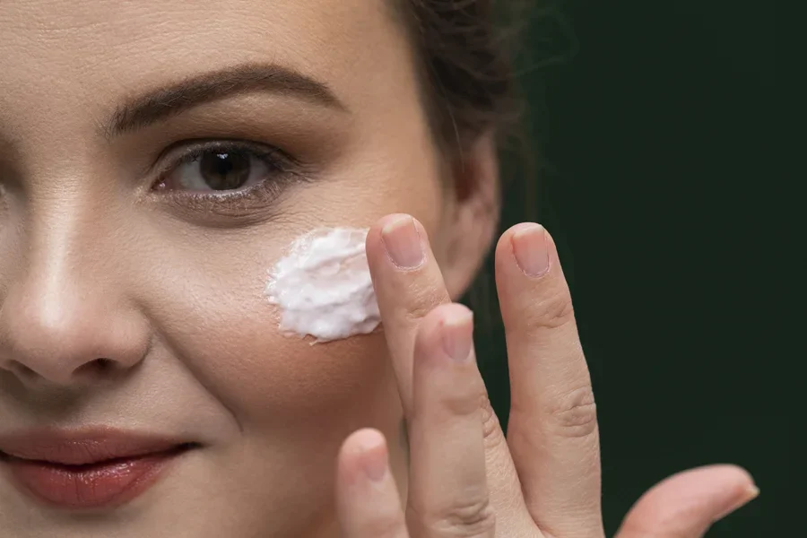 A woman putting on moisturizer