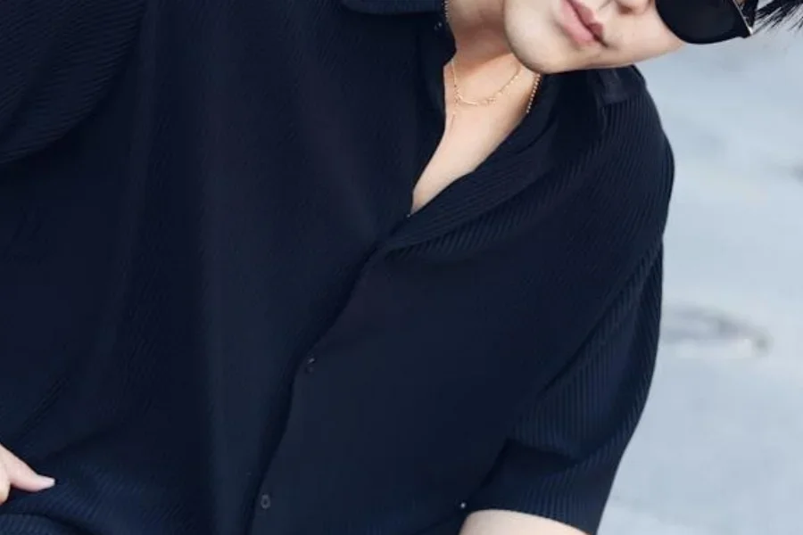 Homem asiático com camisa preta grande e óculos de sol estilosos