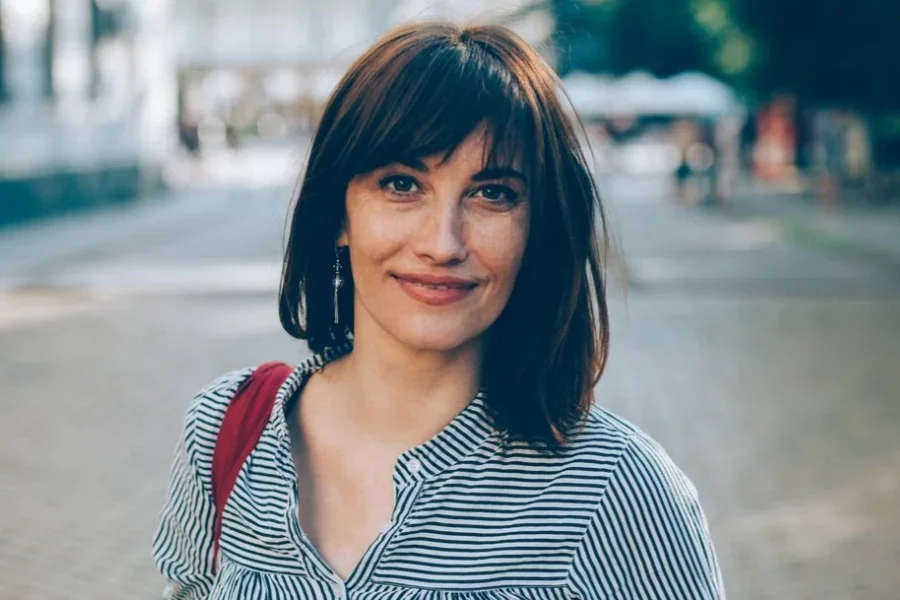 Красивая женщина с челкой на открытом воздухе