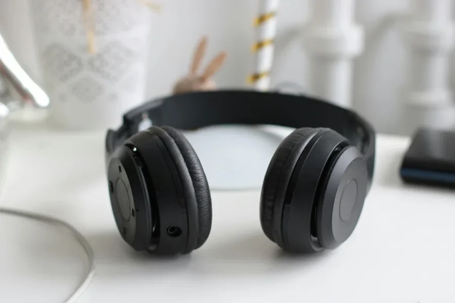 Close-up of black wireless headphones on a white desk in a modern setting