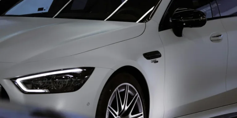 Gros plan d'une voiture de luxe blanche Mercedes Benz dans une salle d'exposition mettant en valeur le design avant élégant