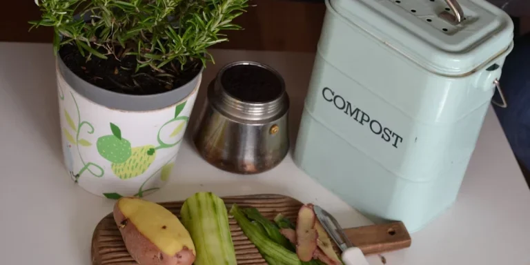 Compost bin on the counter next to a cutting board with food