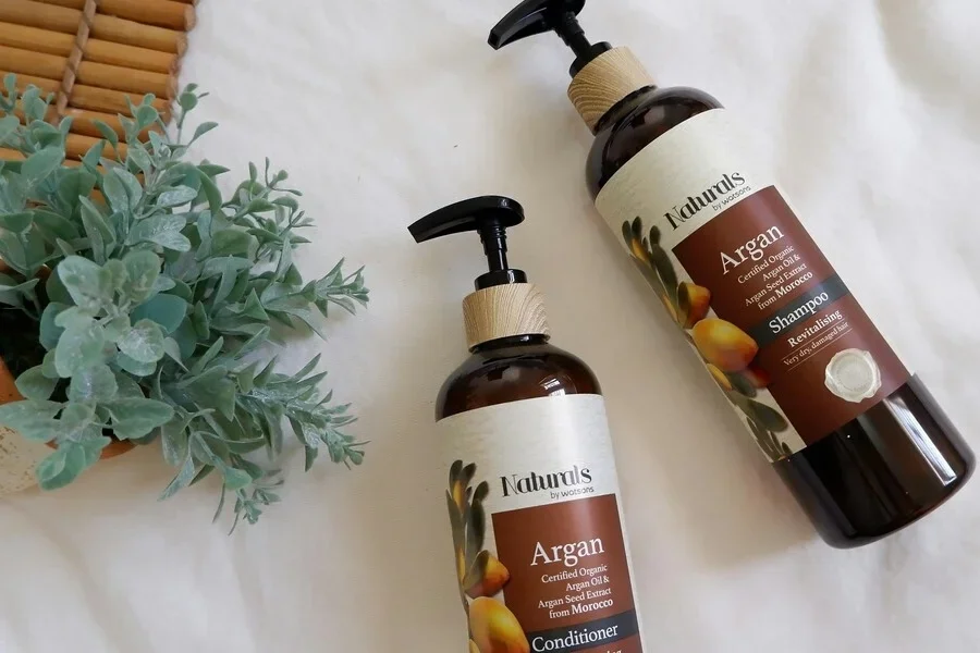 Средства для волос с аргановым маслом, нанесенные на белую поверхность