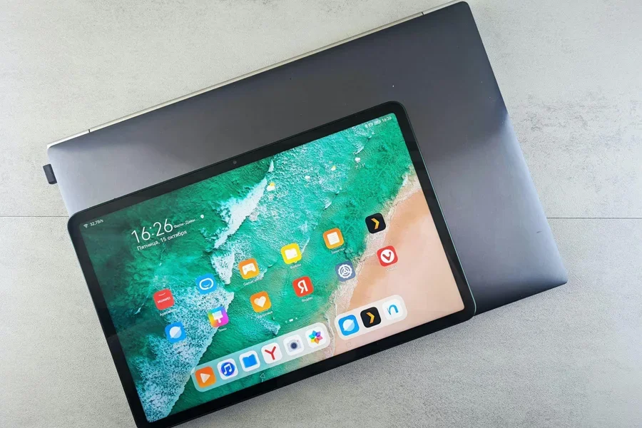 Laptop and tablet compared together on the grey background