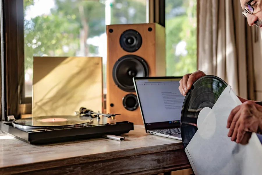 Man holding record near turntable