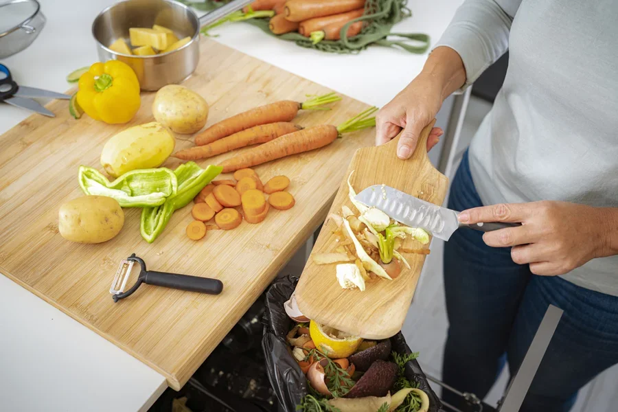 Person moving food scraps into a bin