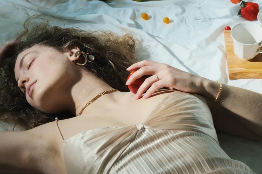 Relaxed woman with fruit lying on blanket