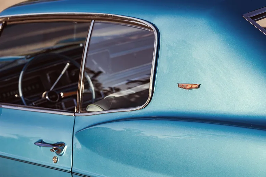 Vue latérale d'une Chevrolet Caprice vintage de 1966 en bleu classique, mettant en valeur un design rétro