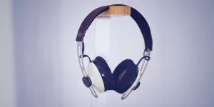 Sleek modern headphones displayed on a minimalist stand in a neutral setting