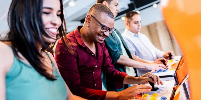 Trois collègues jouent à l'arcade dans une salle de jeux