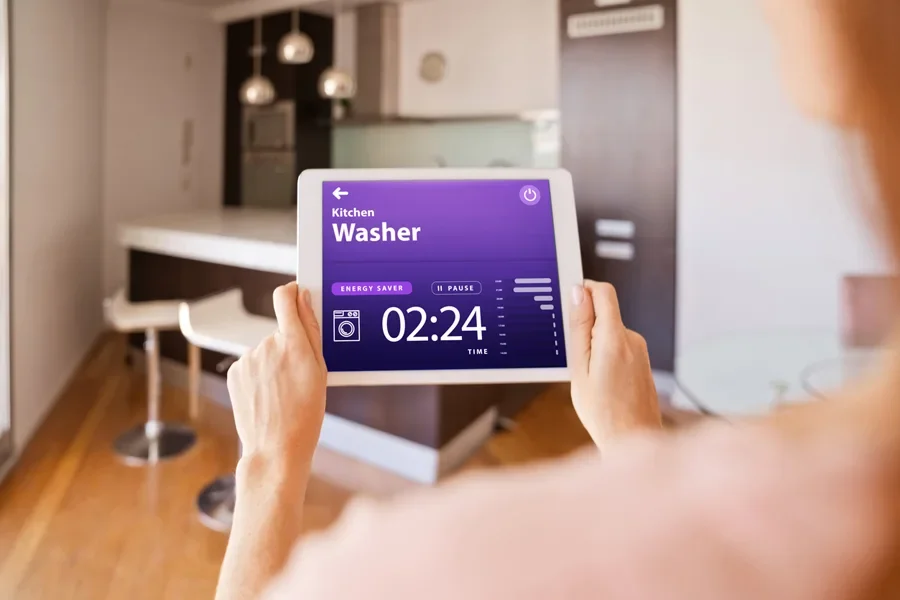 Woman Controlling Washer with a Digital Tablet at Home