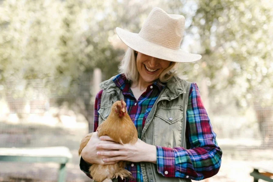 Mujer sosteniendo un pollo marrón