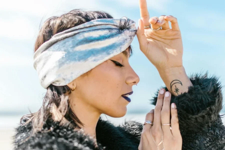 Wanita Bermantel Bulu Hitam Mengenakan Topi Putih dan Biru