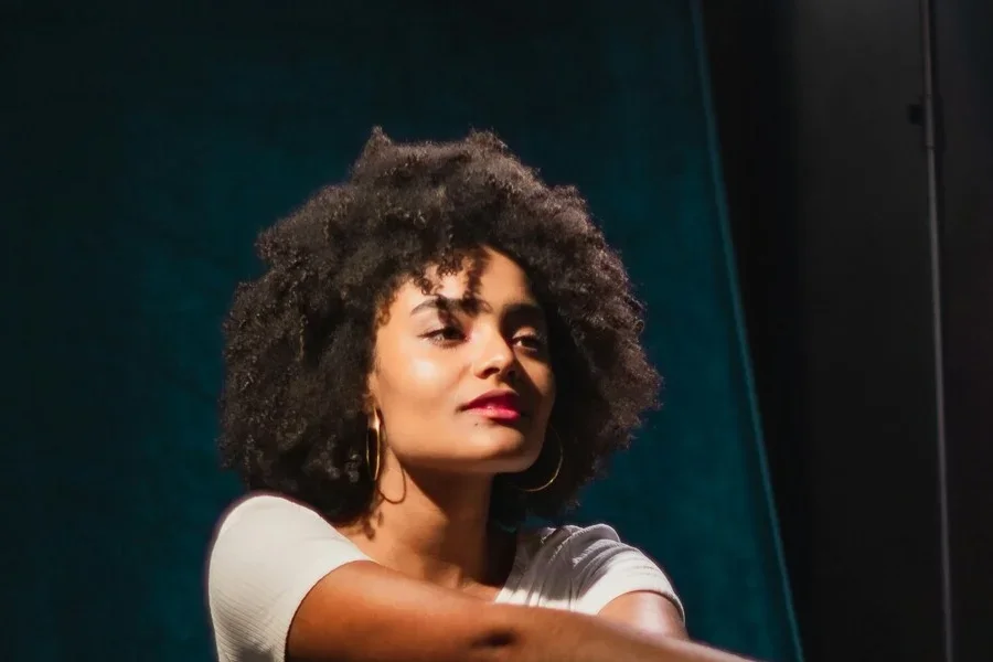 Женщина с вьющимися волосами 4c позирует