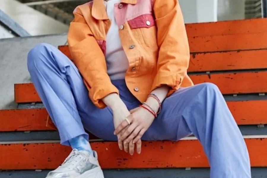 Jovem mulher asiática com jaqueta laranja e jeans