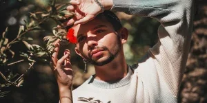 Jeune homme posant avec une fleur