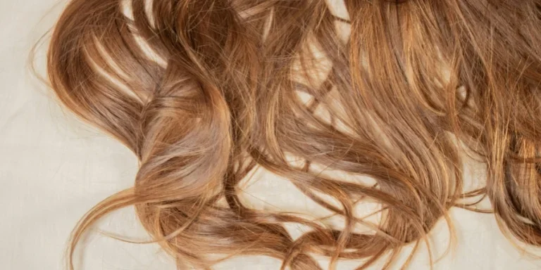a close up of a woman's hair laying on a bed