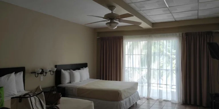 a hotel room with two beds and a ceiling fan
