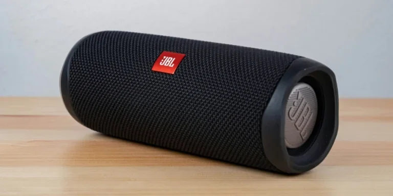 speaker portabel jbl hitam di atas meja kayu coklat