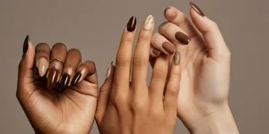 Diverse hands showcasing coffee-toned manicures with glossy and marble swirl accents.