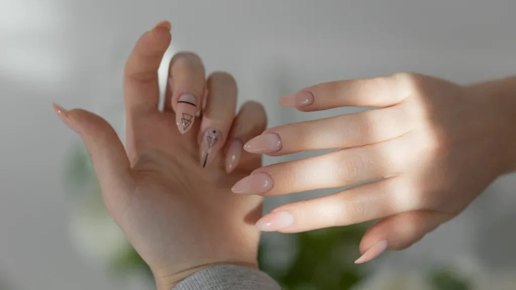 Elegante, feminine Hände mit beigefarbenen Mandelnägeln, Nahaufnahme einer glamourösen Maniküre Elegante, feminine Hände mit beigefarbenen Mandelnägeln, Nahaufnahme einer glamourösen Gel-Maniküre