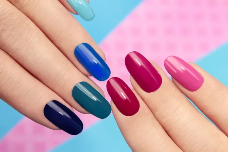 Vernis à ongles bleu rose sur ongles longs sur fond coloré.