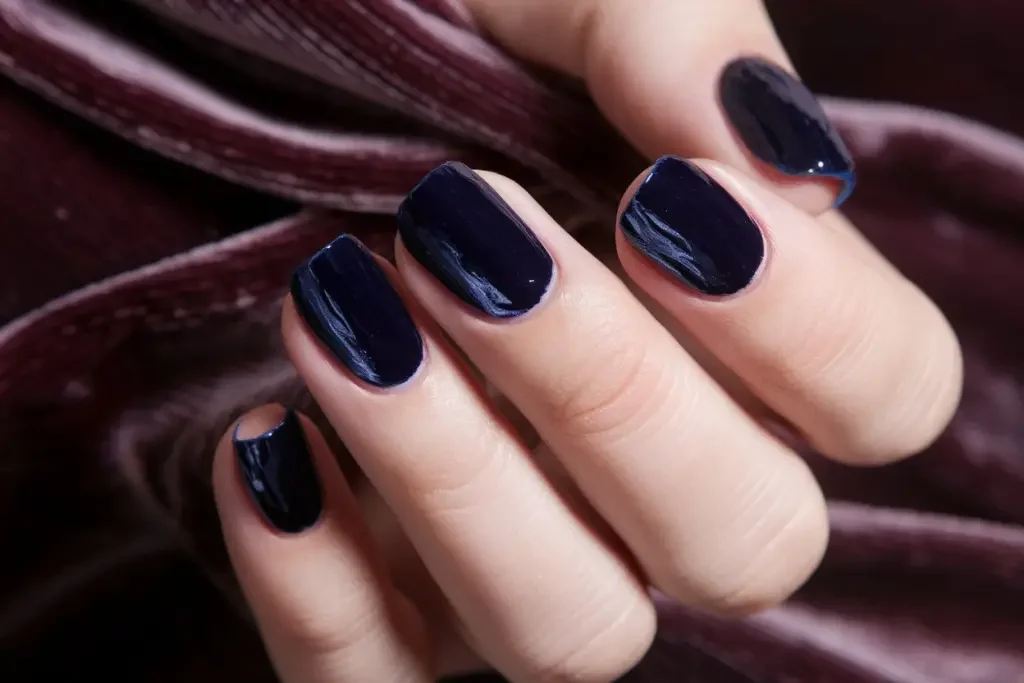Reichhaltige Nägel mit Samt-Finish in juwelenblauen Tönen, strukturiert und fühlbar mit passendem Stoff
