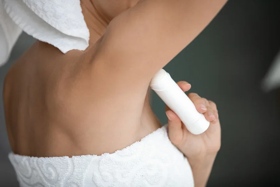 A woman applying a stick deodorant