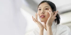 A woman applying moisturizer