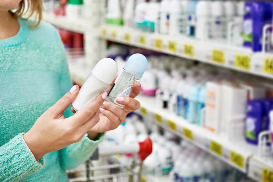 A woman comparing deodorant in a store