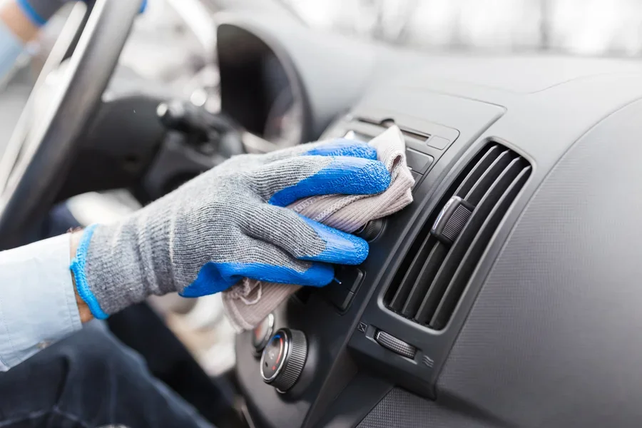 Auto service staff hand cleaning car interior with microfiber cloth. Car detailing and valeting concept