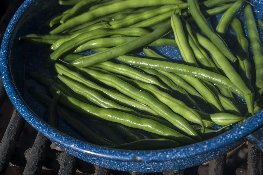 Panci keramik biru jintan dengan kacang hijau untuk memasak