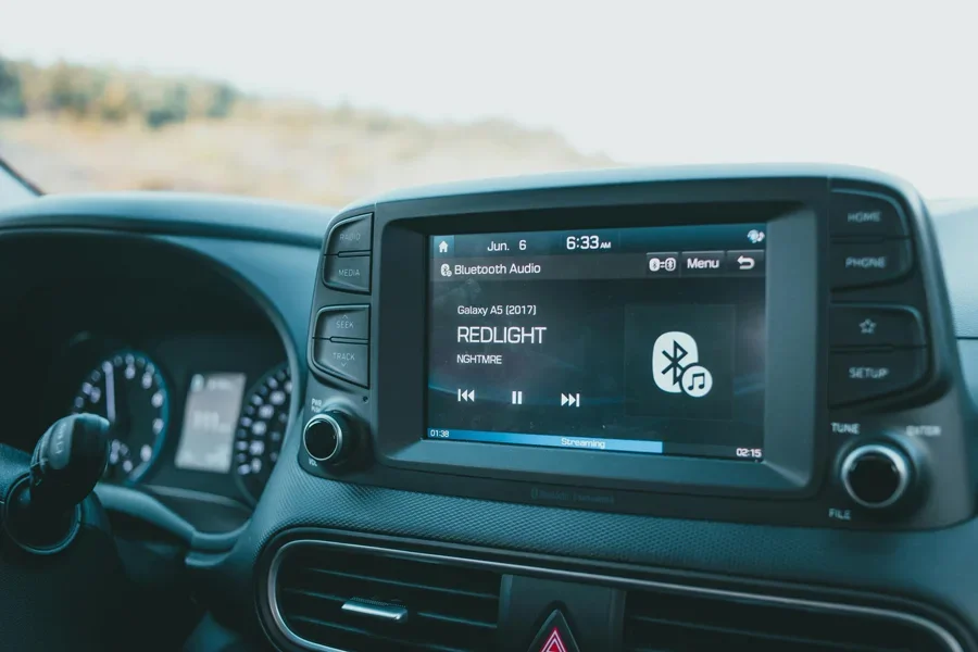 Close-up of a car dashboard featuring a Bluetooth audio system with music display