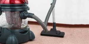 Close-up of a modern vacuum cleaner with water filtration on carpet floor indoors