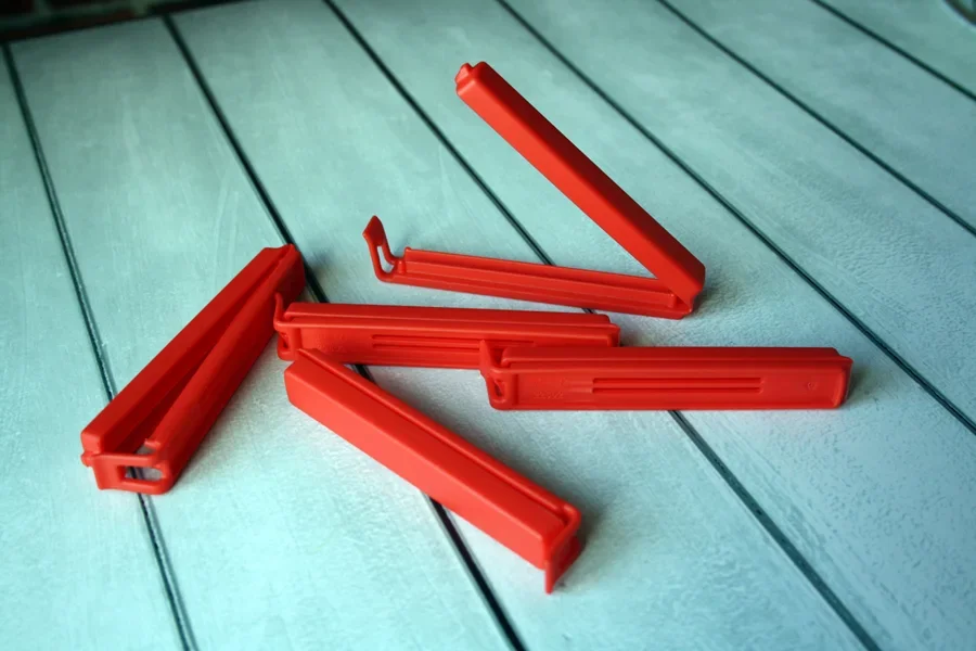 Pack of fold-over back clips on teal colored wooden table