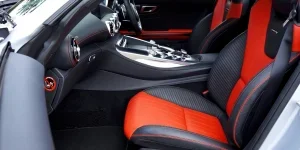 Sleek, modern car interior featuring red and black leather seats and advanced dashboard controls