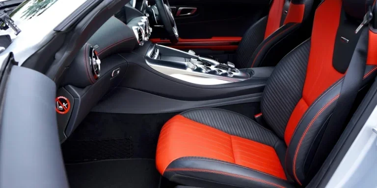 Sleek, modern car interior featuring red and black leather seats and advanced dashboard controls