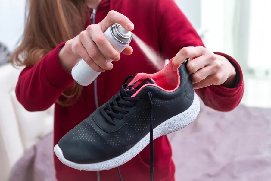 A Young Woman Spraying Deodorant on Shoes