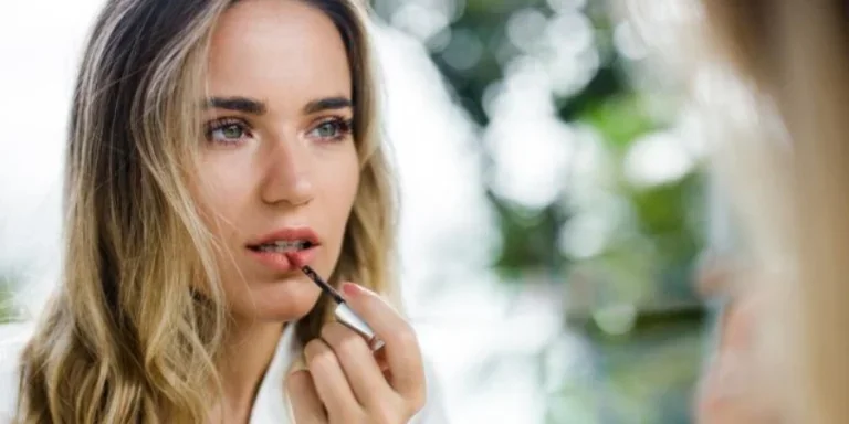 Reflection in a Mirror of beautiful woman Applying Lip Gloss